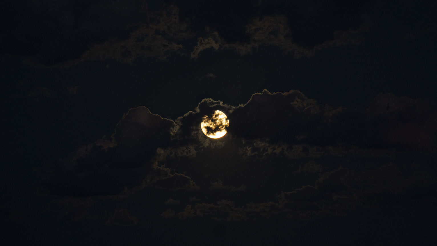 The moon partly obscured by clouds